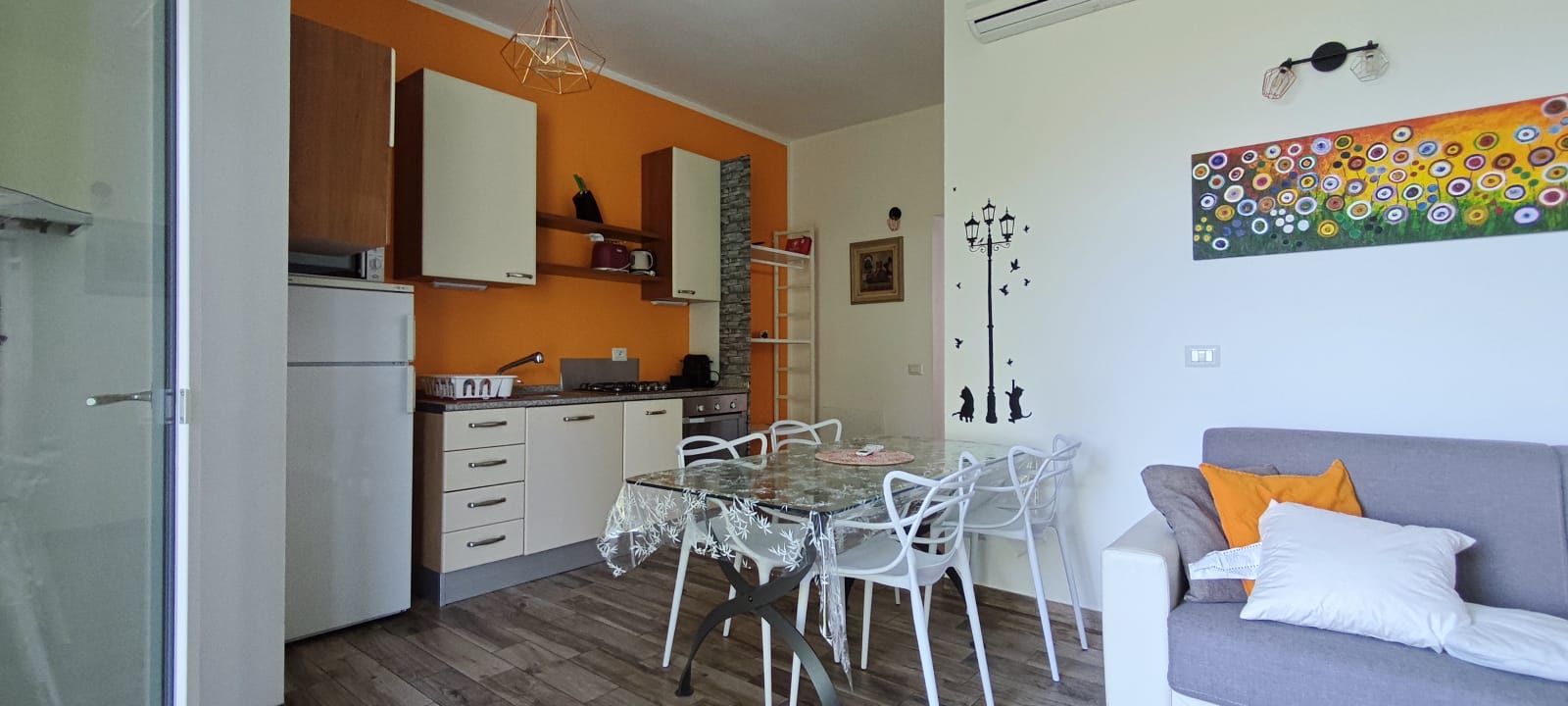 Appartamento 3.Arancio — zona giorno con cucina, tavolo e divano
