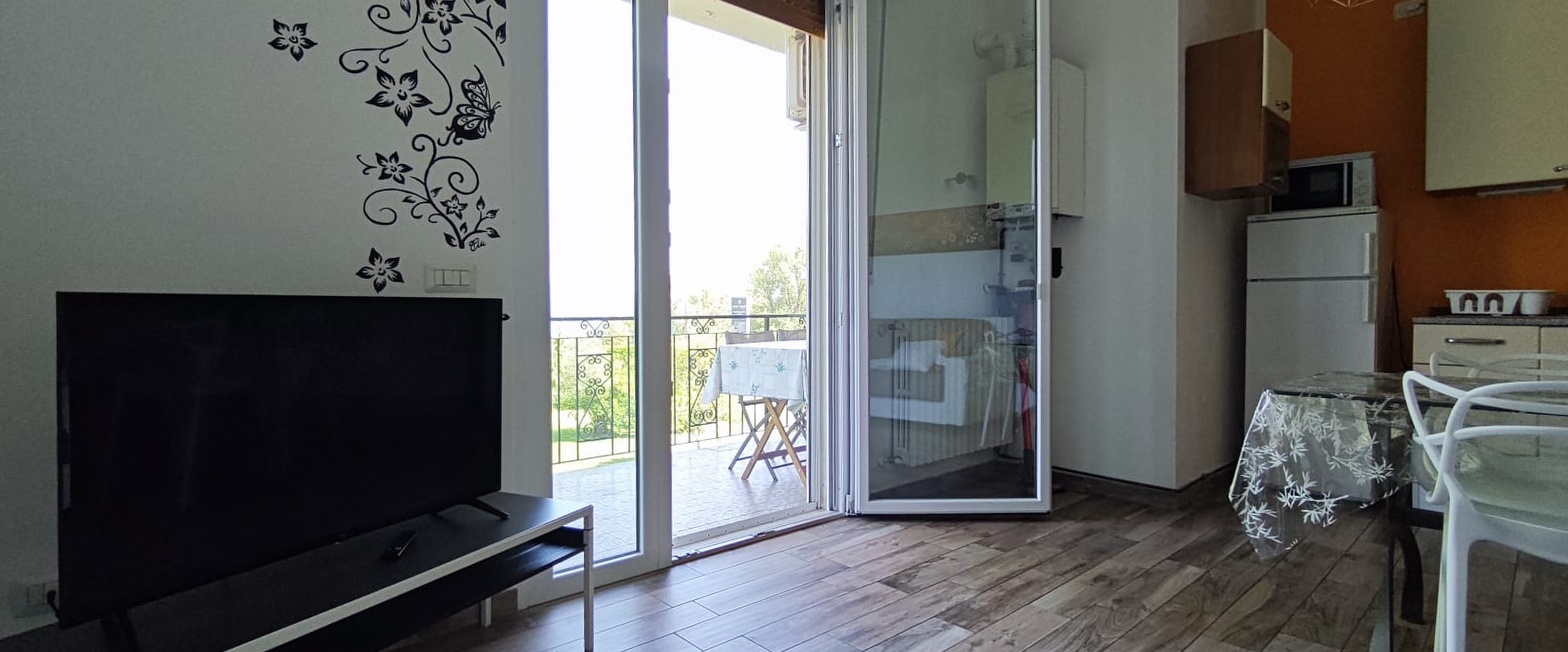 Appartamento 3.Arancio — soggiorno con Smart TV e porta finestra sulla terrazza