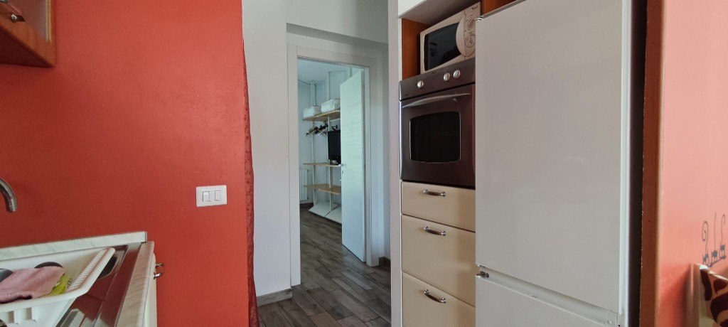 Appartamento 2.Rosso — passaggio tra cucina e zona notte con colonna attrezzata