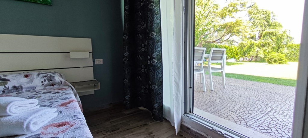 Appartamento 2.Rosso — affaccio della camera sul patio e sul giardino