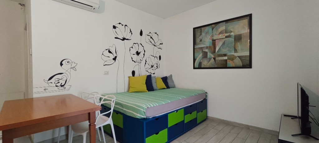 Appartamento 1.Verde — zona giorno con divano letto, tavolo e Smart TV