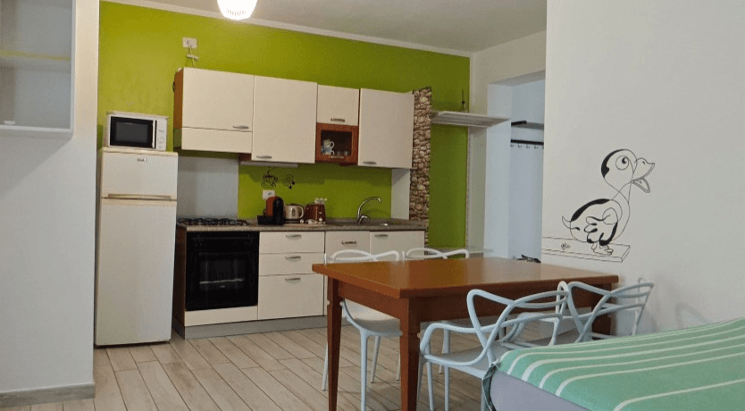 Appartamento 1.Verde — cucina attrezzata con parete verde e zona pranzo