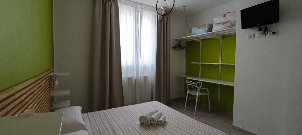 Appartamento 1.Verde — camera matrimoniale vista verso armadio e Smart TV